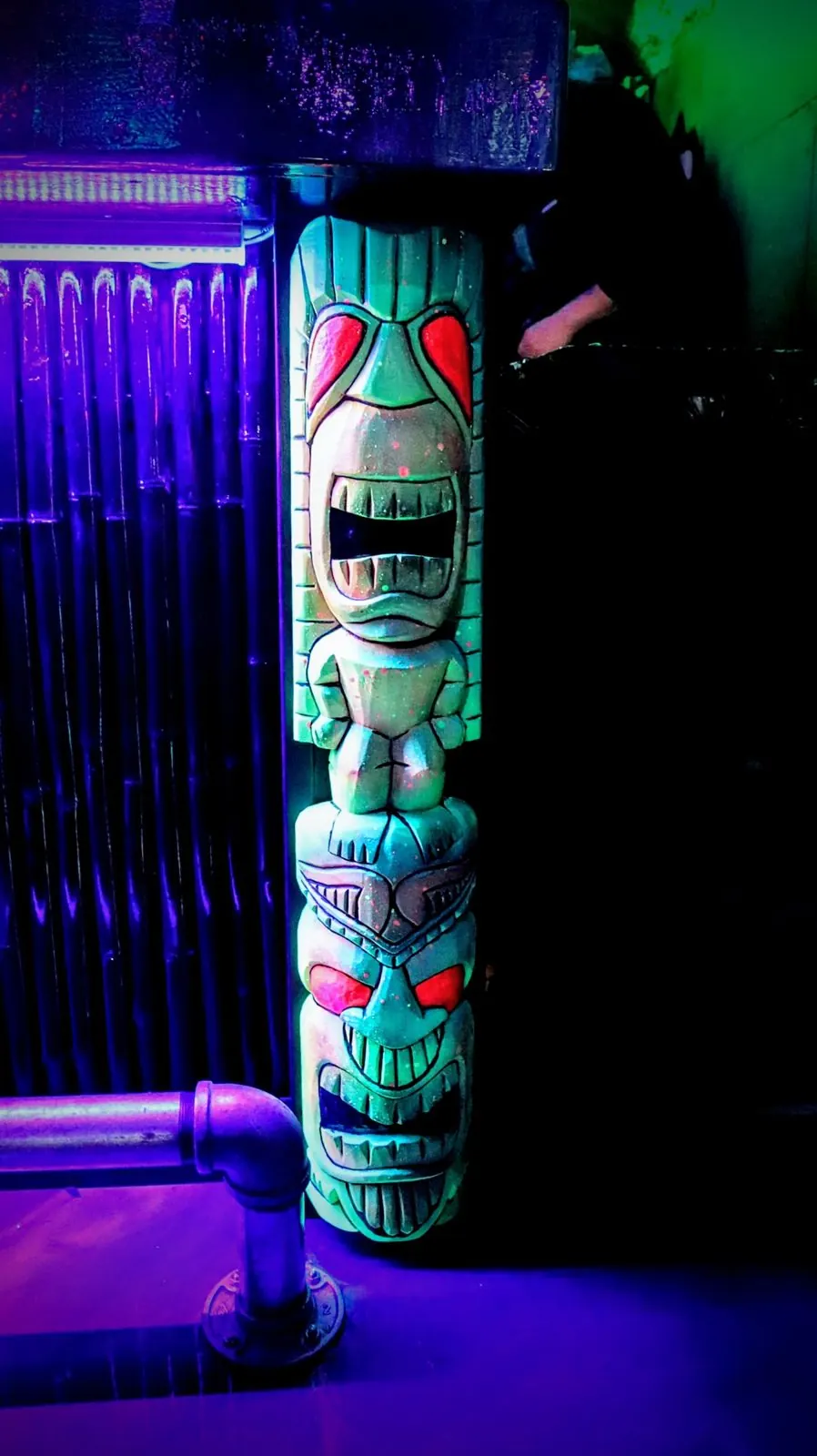 A carved tiki totem under purple light